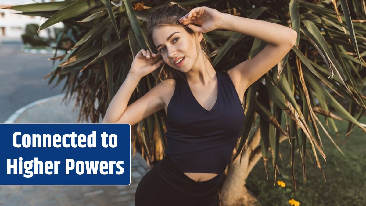 Charming amazing young woman in sportswear smiling on tropical tree.