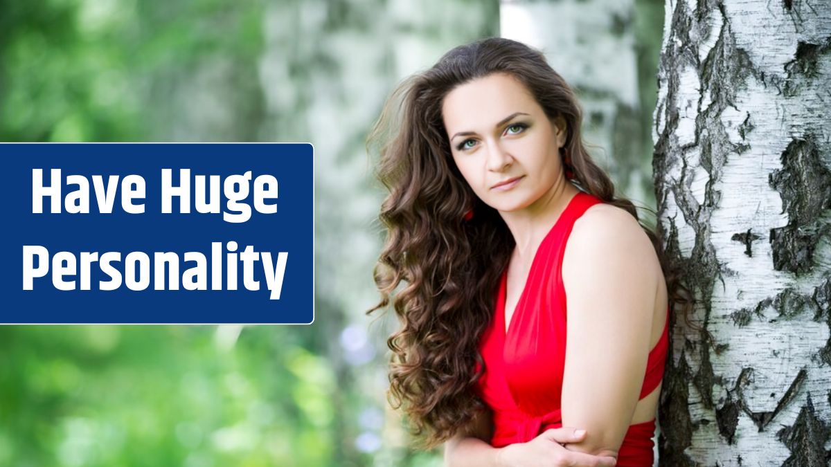 Beautiful young caucasian brunette woman in red dress outdoors.