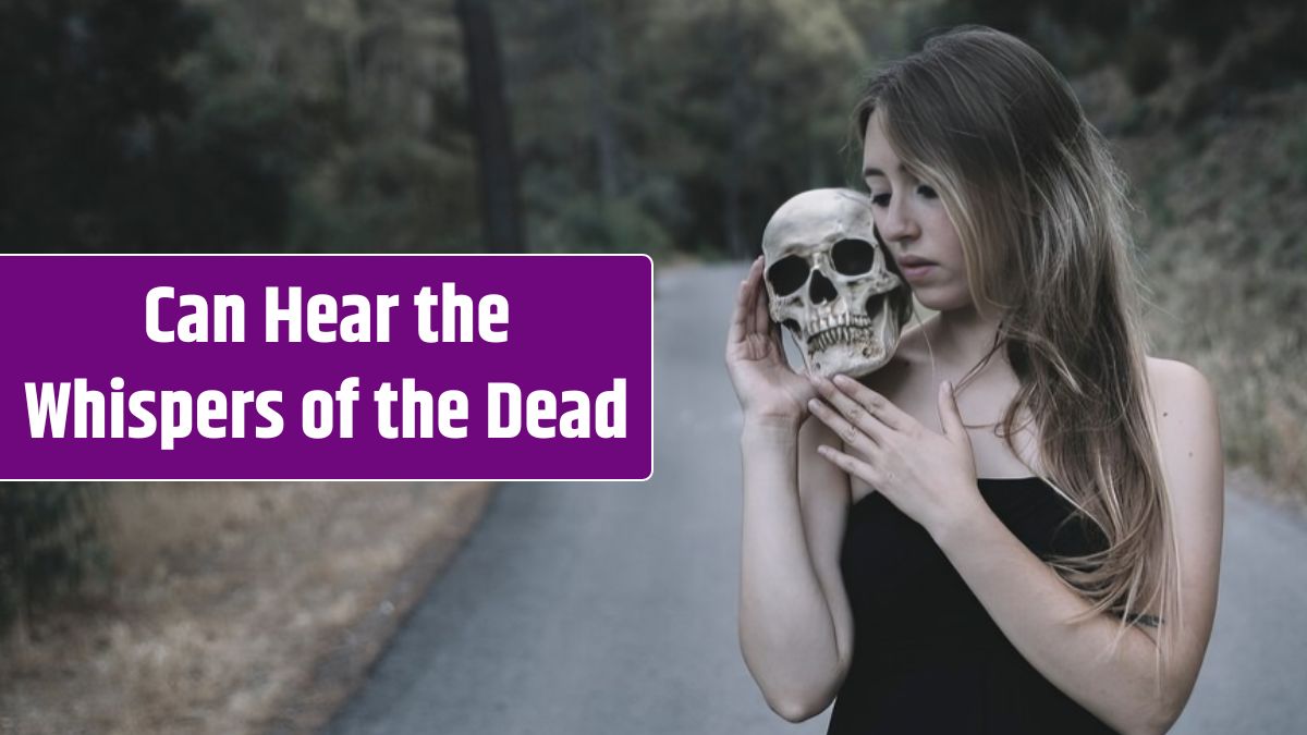 Woman holding a decorative human skull on shoulder standing on road.